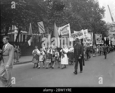 2000 rally in parata di ritmo. Marzo a Hyde Park. 2000 membri dell'organizzazione giovanile britannica, che indossano i costumi nazionali dei paesi pacemolenti. Ha preso parte al gigantesco concorso di pace rally a Hyde Park. Spettacoli fotografici, la processione, guidata da ragazze in costume nazionale cecoslovacco, passando giù per l'argine Victoria a Hyde Park. Nella processione vengono portate fotografie di Lenin. 20 giugno 1937 Foto Stock