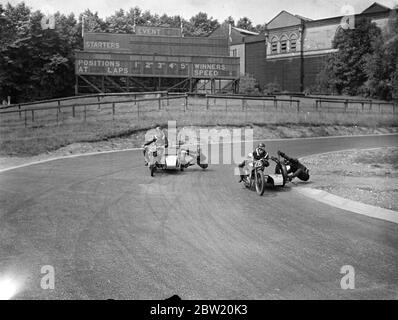 I motociclisti hanno fatto pratica finale sul circuito di Crystal Palace Road Racing per la riunione del Gran Premio di Londra di oggi (sabato). John Surtees (23) e T. F. Pullin (28) lottano per la guida sul tuffo stadio. 17 luglio 1937. Foto Stock