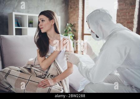 Foto di giovane ammalato piangendo paziente signora seduta divano malessere chiamata emergenza doc virologo influenza freddo covid iniezione mano spalla farmaco aiuto usura Foto Stock