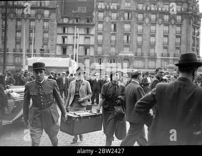 Aiutare il marito alla 'parte anteriore'. Un gran numero di reserviisti francesi stanno lasciando la Gare l'Est a Parigi per posta sulla linea Maginot, le grandi fortificazioni sulla frontiera orientale. Dopo la richiesta dei reservisi, la Francia, come più di 1 milione di uomini in armi nel caso in cui dovrebbe essere chiamata a rispettare i suoi obblighi di trattato nei confronti della Cecoslovacchia. Foto mostra, moglie di un ufficiale, aiutando suo marito a portare il suo tronco alla Gare de l'Est, mentre partiva per la linea maginot. Entrambi sembrano seri. 25 settembre 1938 Foto Stock