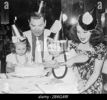 Cerimonia di taglio della torta dei "referenti" di Dempsey alla festa di compleanno della figlia. Jack Dempsey, in carta, e sua moglie, l'ex Hannah Williams, sovrintendono il taglio della torta alla festa data per celebrare il secondo compleanno della loro figlia, Joan (a destra). Barbara, l'altra figlia, di quattro anni, sta eseguendo la cerimonia al ristorante Broadway di Dempsey (New York). 5 settembre 1938 Foto Stock