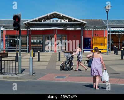 Donna in traversata pedonale di fronte alla stazione ferroviaria, Goole, East Yorkshire, Inghilterra UK Foto Stock