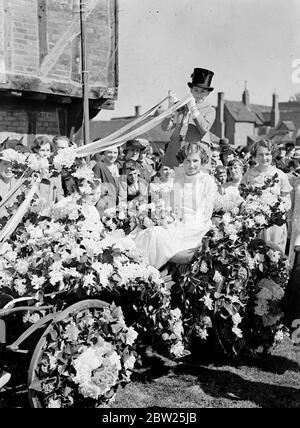 May Queen incoronata nel villaggio del Bedfordshire. Kathleen Goode e Elstow, la studentessa, sono state incoronate. May Queen sul villaggio verde a Elstow, Bedfordshire luogo di nascita di John Bunyan. La Regina di maggio passò attraverso il villaggio su un carro disegnato dai suoi compagni di scuola, con un maypole portato davanti a lei. L'incoronazione è stata effettuata dalla Regina di maggio dello scorso anno, Maisie Goodship. Foto mostra, Kathleen Goode la Regina di maggio nel suo carro. 5 maggio 1938 Foto Stock