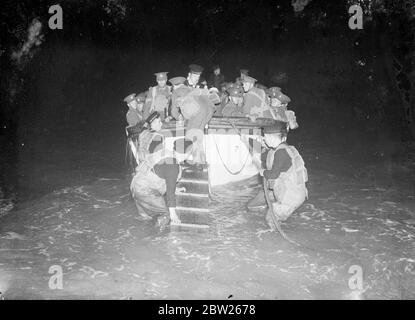 Truppe 'nemiche' atterrano sulla costa meridionale, l'esercito e la marina cooperano in esercizi tattici. Truppe della nona Brigata di Fanteria hanno collaborato con le navi della flotta di Home in un esercizio di atterraggio combinato sulla costa del Devon. Sotto la copertura di un incendio da navi da guerra, le truppe sbarcarono, consolidarono la loro posizione e portarono attrezzature a terra. Una battaglia è prevista prima che le truppe siano costrette a reimbarcarsi. Spettacoli fotografici - valutazioni navali che aiutano le truppe a sbarcare sulla costa del Devon vicino a Dartmoor. 6 luglio 1938 Foto Stock