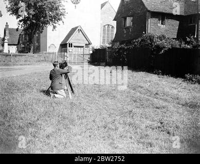 Un cameraman che filma di fronte alla chiesa del villaggio di Otford, Kent. 1933 Foto Stock