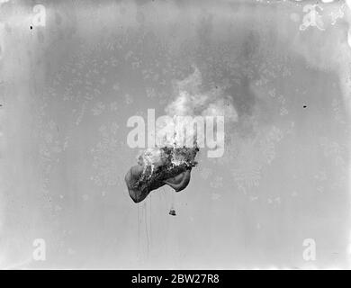 Un pallone da aquilone è stato portato giù in fiamme durante l'attacco contro Kite Balloons evento all'annuale Royal Air Force Pageant presso l'aeroporto di Hendon. Gli ultimi aerei da guerra e i migliori piloti hanno dato una mostra emozionante alla presenza del Re e della Regina e di altri membri della Famiglia reale - un quadro composito. 26 giugno 1937 Foto Stock