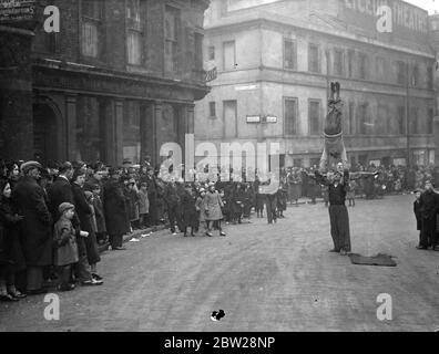 Lo spettacolo extra per le code di pantomime del giorno di Santo Stefano. "Buskers" offre ulteriore intrattenimento per le code del giorno di Santo Stefano che aspettano fuori dal Teatro Lyceum per vedere la pantomima "Beauty and the Beast". 27 dicembre 1937 Foto Stock