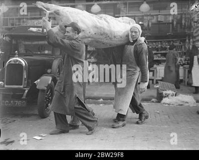 Un barone di manzo, del peso di 30 pietre è arrivato al mercato di Smithfield sulla sua strada per il banchetto del Signore Sindaco, che si svolge il 9 novembre . Spettacoli fotografici, facchini che trasportano due pesanti baroni di manzo a Smithfield. 5 novembre 1937 Foto Stock