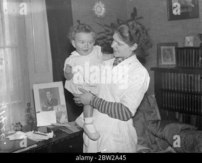 L'infermiera salva il bambino da casa che si è liberata. La signora Eileen Campeggio, un'infermiera per bambini, ha attraversato le fiamme per salvare Andrew Rudolf, 10 mesi, quando è scoppiato un incendio a casa di MR e Mrs Rudolf a Westbourne Terrace Road, Harrow Road. La sig.ra Rudolf si svegliò e si corse nella stanza del bambino, lo avvolse in una coperta e lo trasportò in sicurezza. Al piano inferiore. Un contatore ospite era minacciato dalle fiamme e un'esplosione è stata evurata da Rudolph con secchi d'acqua. Spettacoli fotografici, Miss Eileen campeggio con Andrew Rudolf, di 10 mesi, dopo l'avventura del fuoco. 25 novembre 1937 Foto Stock