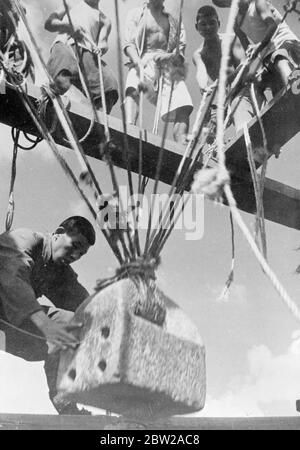 La 'potenza del riso' costruisce un muro intorno alla concessione francese a Shanghai, il primitivo pilone-driver usato dagli ingegneri moderni. Il metodo primitivo di guida su palo, di centinaia di anni, viene utilizzato per la costruzione da parte dei francesi di un muro di mattoni per proteggere la concessione francese lungo il confine con Nantao e Siccawei a Shanghai. Il driver del palo 'potere del riso', come è chiamato, consiste di una pietra pesante, che è tirata in su da coolies che stucco in unisono ad un canto antico. Quando è stato tirato in su, la pietra è lasciata cadere sul palo. Foto mostra, la pietra massiccia del 'potere di riso' driver palo Foto Stock