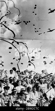 Soldati sovietici galleggiano sulla terra sopra la folla durante un salto di massa paracadute che è stato una caratteristica della mostra al giorno sovietico dell'aria. Joseph Stalin, che causa la costernazione mondiale con il suo patto proposto con la Germania, guardò con 1 milione di persone come bombardieri e combattenti dell'aeronautica sovietica impegnati in una guerra imitazione sull'Aerodromo di Tushino, Mosca. 23 agosto 1939 Foto Stock