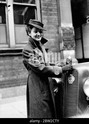 Un cappotto e cappellino, approvati ufficialmente dai servizi volontari delle Donne per la Difesa civile per l'uso dei suoi membri sono stati presentati presso gli uffici dei servizi volontari delle Donne a Tothill Street, Londra. Foto: La signora John Dunlop, una delle prime volontari che fissa il nuovo distintivo dei servizi volontari delle donne ad un'auto. Il logo sostituisce il logo ARP precedentemente utilizzato . 28 giugno 1939 Foto Stock