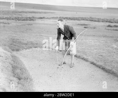 Giocando con arco e freccia, il maggiore J G Hayter, riconosciuto esperto dello sport annuale di prua e freccia di golf, ha incontrato il colonnello e St George Kirke, il capitano del club, in una partita al Hankley Common Golf Club, Surrey. Ha ammesso un colpo una balla. Major Hayter spara la sua freccia in una scatola invece di un buco. La sua media per la maggior parte dei corsi di Surrey è negli anni settanta. Foto mostra: Major J G Hayter stropica la sua freccia da un bunker, perdendo così un colpo o un colpo. 18 ottobre 1938 Foto Stock