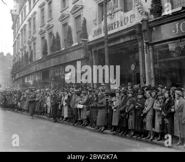 Una folla di negozi a Kensington gira le spalle sulla vetrina per assistere al matrimonio di Hon James Lindsay e Hon Bronwen Scott-Ellis a St Mary Abbotts. 26 aprile 1933 Foto Stock
