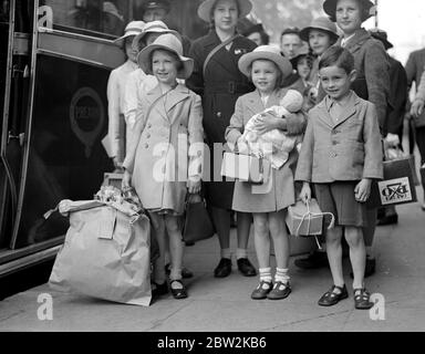 Crisi di guerra, 1939. Le precauzioni contro i RAID aerei iniziarono la seconda guerra mondiale e gli evacuati, come questi in questa foto, iniziarono a riversarsi fuori Londra per la sicurezza delle campagne. Trasportando le casse della maschera a gas, le etichette dei bagagli che le identificano, fissate ai loro vestiti, era per alcuni di loro una grande avventura, perché molti di loro non avevano mai lasciato la sede, o persino Londra prima. 3 settembre 1939 Foto Stock