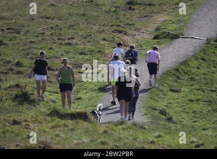 Gli escursionisti praticano la divaricazione sociale su Dumyat vicino a Stirling , poiché le persone possono incontrare la famiglia e gli amici all'aperto e giocare a sport come il golf e il tennis di nuovo, mentre il paese si sta muovendo nella fase uno del piano del governo scozzese per il graduale sollevamento blocco. Foto Stock