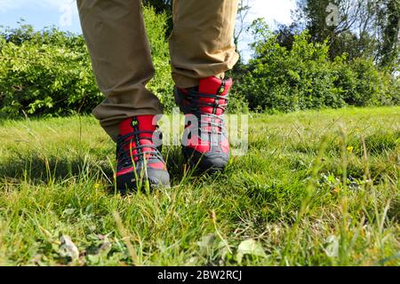 Gambe uomo che camminano all'aperto con un paio di Merrell Red Raccal o Sport GORE-TEX Trail Shoes Foto Stock