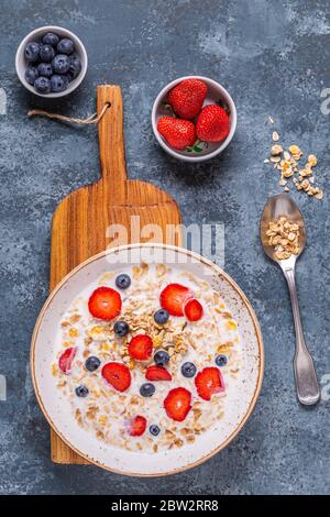 Colazione sana, ciotola con granola di avena, latte e bacche, vista dall'alto. Foto Stock