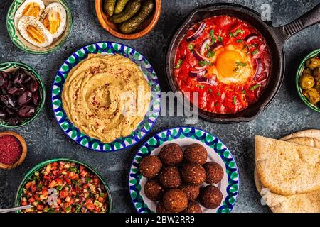 Falafel, hummus, shakshuka, insalata israeliana - piatti tradizionali della cucina israeliana. Vista dall'alto. Foto Stock