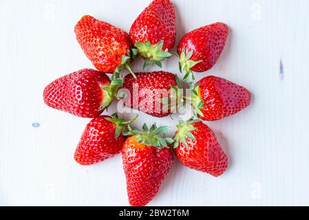 Fragole mature disposte in cerchio, su un piatto bianco. Foto Stock