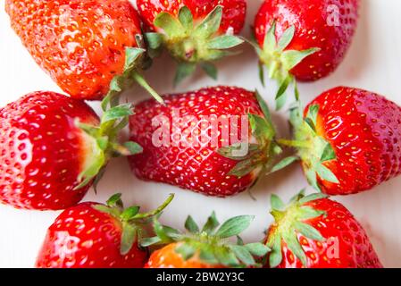 Fragole mature disposte in cerchio, su un piatto bianco. Foto Stock