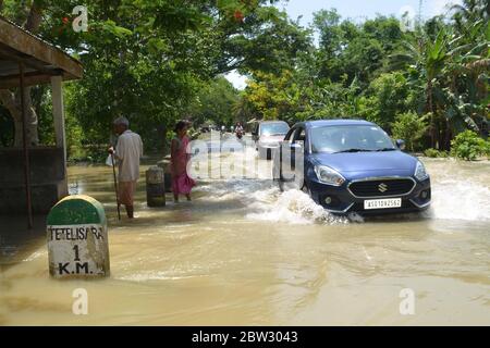 Nagaon, Assam / India - 29 2020 maggio: Le persone sulle loro auto che attraversano la strada allagata a Tetelisara villaggio colpito da alluvione vicino a Kampur nel distretto di Nagaon di Assam Venerdì. Credit: Dita TALUKDAR/Alamy Live News Foto Stock