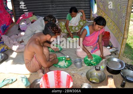 Nagaon, Assam / India - 29 2020 maggio: Abitanti del villaggio mangiare cibo sotto capannone temporaneo costruito su altopiano come le loro case sono sotto l'acqua in alluvione colpito Tetelisara villaggio vicino Kampur nel distretto di Nagaon di Assam il Venerdì. Credit: Dita TALUKDAR/Alamy Live News Foto Stock