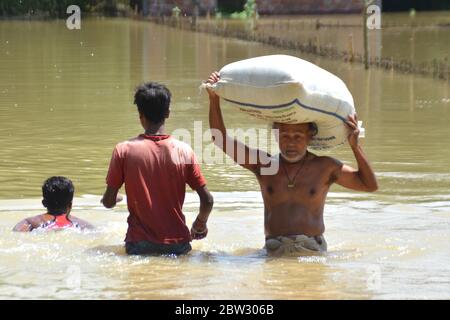 Nagaon, Assam / India - 29 2020 maggio: Una vittima colpita da un'inondazione che ha portato fuori i grani di cibo sulla sua testa in un luogo sicuro in alluvione colpito Tetelisara villaggio vicino a Kampur nel distretto di Nagaon di Assam il venerdì. Credit: Dita TALUKDAR/Alamy Live News Foto Stock