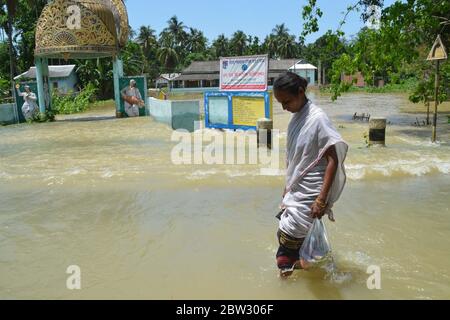 Nagaon, Assam / India - 29 2020 maggio: UNA donna con verdure sulla sua mano che guastano la strada allagata a Tetelisara villaggio colpito alluvione vicino Kampur nel distretto di Nagaon di Assam il venerdì. Credit: Dita TALUKDAR/Alamy Live News Foto Stock