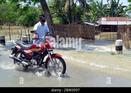 Nagaon, Assam / India - 29 2020 maggio: Un uomo che tira la sua moto attraverso la strada allagata in alluvione colpito Tetelisara villaggio vicino a Kampur nel distretto di Nagaon di Assam Venerdì. Credit: Dita TALUKDAR/Alamy Live News Foto Stock