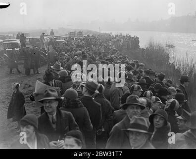 L'84° gara annuale di barche tra Oxford e Cambridge sul Tamigi . Folle sulla riva guardando il finale della gara . 19 marzo 1932 Foto Stock