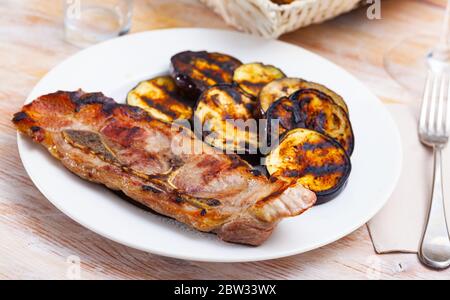 Appetitoso spalla di maiale fritta con melanzane servite al piatto Foto Stock