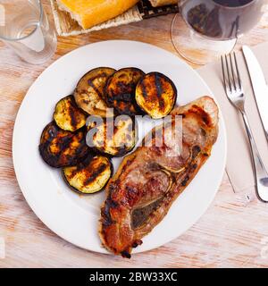 Appetitoso spalla di maiale fritta con melanzane servite al piatto Foto Stock