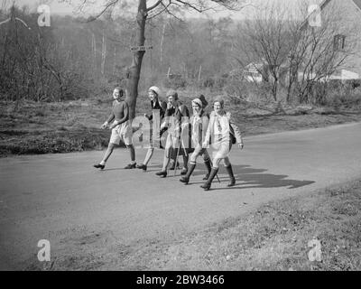 Il richiamo della strada aperta . Il sole di primavera ha reso Pasqua una vacanza all'aperto e migliaia di persone l'hanno goduta sulla strada aperta . Girl escursionisti sulla strada in Surrey . 27 marzo 1932 Foto Stock