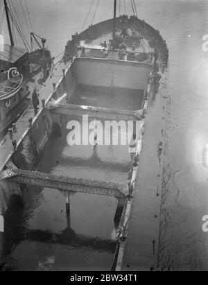 Riparazioni effettuate al letto del fiume sotto il ponte della torre . I lavori di riparazione sono in corso nel letto del Tamigi adiacente al Tower Bridge , dal porto di Londra . Il letto del fiume è stato scavato a questo punto da correnti e grandi quantità di zavorra sono state scaricate per riempire i fori in modo che non vi sia pericolo che le fondamenta del ponte siano messe in pericolo. Un drago impaccatura zavorra sotto il Tower Bridge per riempire i fori sotto il ponte . 8 marzo 1932 Foto Stock