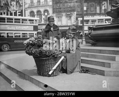 Piccadilly fiore ragazze per partecipare alla palla di fiori della società . Polly e nell , che hanno venduto i loro fiori sotto la statua di Eros a Piccadilly Circus , Londra , per anni , saranno gli ospiti di centinaia di persone della società ben conosciute che frequentano la Flower Ball . Saranno accolti da Lady Carisbrooke , figlia - in - legge della principessa Beatrice e una Eros in miniatura sarà eretto nella sala da ballo per farli sentire ' a casa '. Polly e nell si dice siano le ragazze di fiori più famose del mondo . Polly Beecham ( seduto ) e nell ( Lizzie Sanger ) , fotografati sotto Eros a Piccadil Foto Stock