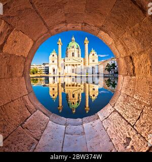 Vienna. Karlskirche chiesa di Vienna riflessione vista attraverso la finestra di pietra, capitale dell'Austria Foto Stock
