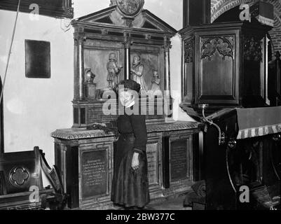Donna verger che è stata presentata alla Regina . Quando la Regina visitò la vecchia chiesa parrocchiale di St Mary' , Stoke Newington , Miss Carrie Houcher , le fu presentato il 66 anni verger . La Regina visitò la Chiesa dopo aver visto un centro disoccupato locale . Quando la sig.ra Houcher si è avanzata per essere presentata ha tenuto un antipolvere in sua mano . Foto spettacoli ; Miss Carrie Houcher alla tomba di Thomas Sutton , il fondatore della Certosa , morto nel 1602 . Questa fu la tomba in cui la Regina mostrò particolare interesse durante la sua visita alla Chiesa . 14 dicembre 1933 Foto Stock
