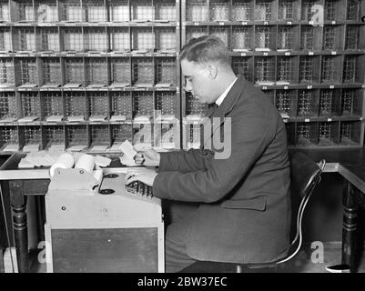 Smistatore robot testato dall'ufficio postale di Brighton . Il lavoro ha accelerato tre volte . Un nuovo smistatore robot che si afferma possa funzionare tre volte più velocemente del sistema utilizzato in precedenza , è stato provato presso l'Ufficio postale generale di Brighton come esperimento . Un operatore che lavora sulla macchina ne può gestire tremila lettere ogni ora . L'operatore siede su una tastiera e, quando preme una delle leve , si apre una presa e una delle lettere su una banda mobile cade in essa . È presente un'apertura appropriata per ogni lettera e tutto ciò che l'operatore deve fare è premere il co Foto Stock