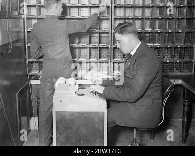 Smistatore robot testato dall'ufficio postale di Brighton . Il lavoro ha accelerato tre volte . Un nuovo smistatore robot che si afferma possa funzionare tre volte più velocemente del sistema utilizzato in precedenza , è stato provato presso l'Ufficio postale generale di Brighton come esperimento . Un operatore che lavora sulla macchina ne può gestire tremila lettere ogni ora . L'operatore siede su una tastiera e, quando preme una delle leve , si apre una presa e una delle lettere su una banda mobile cade in essa . È presente un'apertura appropriata per ogni lettera e tutto ciò che l'operatore deve fare è premere il co Foto Stock