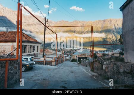 I gasdots sopra il suolo si piegano e si stanciano attraverso un sobborgo nella città di Stepantsminda, Kazbegi, Georgia Foto Stock