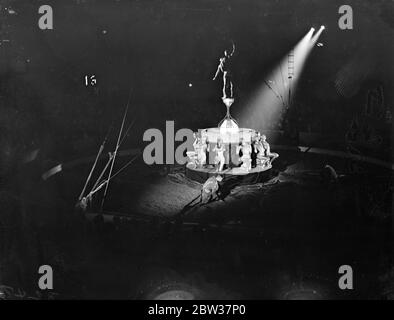 Seimila scolari guardano le prove del circo di Olympia . Seimila bambini hanno assistito alla prova di abbigliamento del circo natalizio di Olympia , a Olympia , Londra . Spettacoli fotografici; gli acrobati si bilanciano su un palo durante lo spettacolo. 21 dicembre 1933 Foto Stock