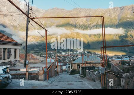 I gasdots sopra il suolo si piegano e si stanciano attraverso un sobborgo nella città di Stepantsminda, Kazbegi, Georgia Foto Stock