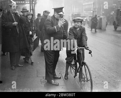 14 anni uomo leader che si sposta in bicicletta verso il teatro West End . Desmond Tester , un ragazzo di Kensington , sta giocando la parte principale in ' What Happen to George ', la produzione teatrale di Wyndham' all' età di 14 anni . E' anche il suo agente e manager . E' probabilmente l' unico' uomo guida' che si mette in bicicletta da e per il teatro . Spettacoli fotografici ; , Desmond Tester riceve un saluto dal commissario all'arrivo al teatro 30 dicembre 1933 Foto Stock