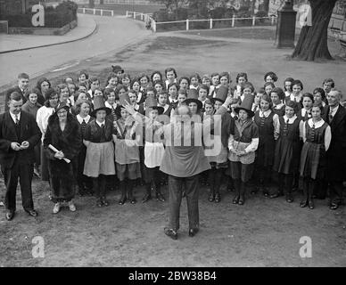 Coro gallese per bambini a Ealing in costume nazionale . I bambini del coro giovanile di Aberaman del Galles hanno praticato su Ealing Green prima di dare un concerto al Municipio di Ealing . Il coro ha vinto oltre 300 premi , di cui 11 premi nazionali . Foto spettacoli , il coro che prova su Ealing Green sotto la direzione del loro direttore , il signor Mitchelmore . 11 aprile 1934 Foto Stock