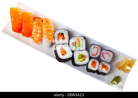 Piatto di sushi giapponese tradizionale. Hosomaki e makizushi con vari ripieni, nigiri con salmone e gamberi. Isolato su sfondo bianco Foto Stock
