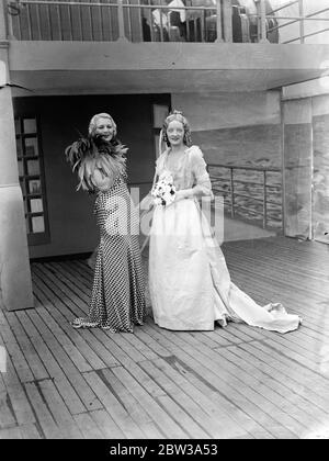 Ragazza con cintura di sedici pollici indossa un abito da sposa 1863 alla festa di compleanno di Whiteley . All Paddington celebra il 71° compleanno di Whiteley' s , uno dei più famosi grandi magazzini di Londra . Una caratteristica delle celebrazioni era una 'Cavalcade della moda' in cui oltre cinquanta dei manichini più belli del mondo mostravano cambiamenti nel campo dell'abbigliamento femminile dal 1863. Tra loro c'erano la signorina Diana Vawsher, la cui vita di sedici centimetri le consentiva di indossare un abito da sposa del 1863. Spettacoli fotografici , Miss Diana Vawsher con l'abito da sposa 1863 . Con lei è una ragazza che indossa una moda moderna . 30 aprile 19 Foto Stock