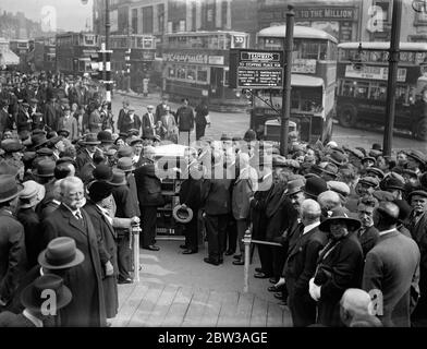 Due Mayor impostano nuovi segnali stradali per il Nord di Londra in funzione . I nuovi segnali di traffico all' Angel Junction , N , sono stati attivati dai Sindaci di Finsbury e Islington . I due Sindaci che iniziano i segnali seguiti da una folla . Tram e autobus in background . A sinistra è il sindaco di Finsbury , Consigliere G Tripp , a destra è il sindaco di Islington , Alderman B Holden . 6 settembre 1934 Foto Stock