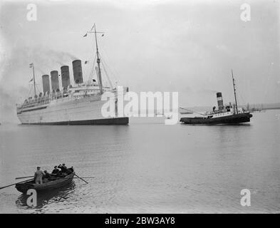 Mauretania da rimontare da non scartare . La figura mostra la nave trainata in porto da una barca di rimorchiatore , uomini in barca a remi in primo piano . 3 ottobre 1934 Foto Stock