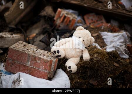 l'orso di teddy in una maschera medica si trova nel cestino Foto Stock